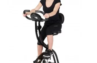 Une femme sur un vélo d'appartement Care Fitness.