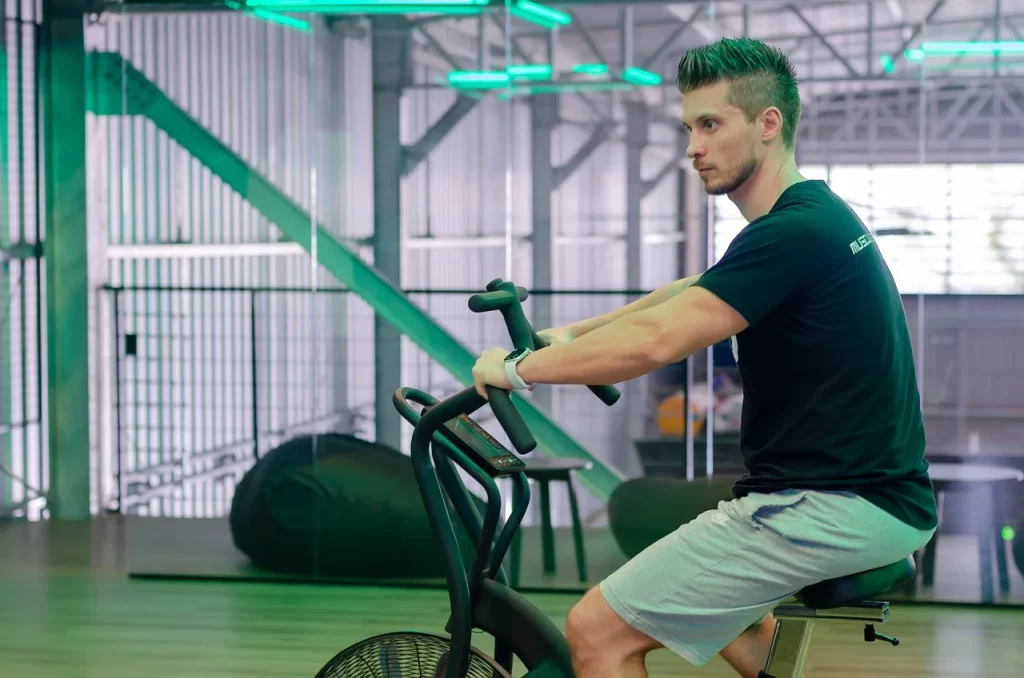 Un jeune homme musclé sur un vélo d'appartement.